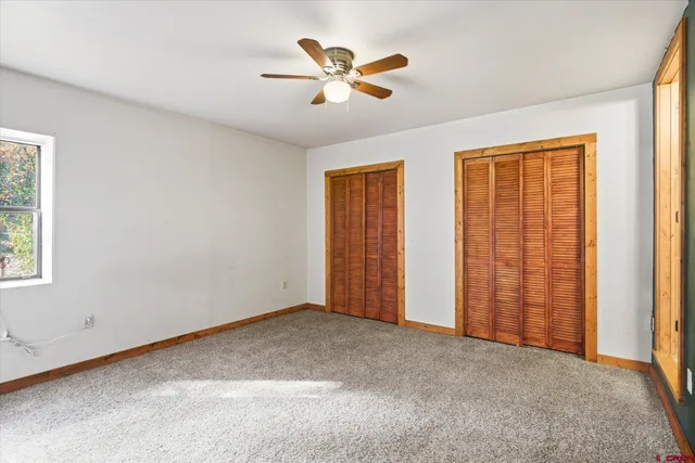 a view of a livingroom with a chandelier fan and windows