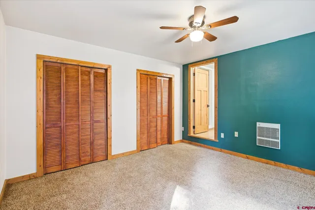a view of a livingroom with a chair and ceiling fan