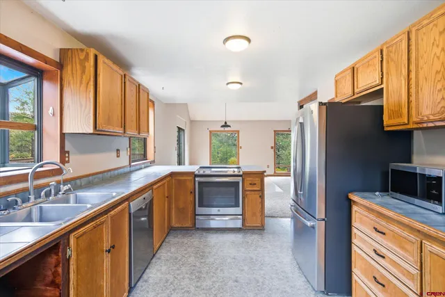 a kitchen with stainless steel appliances granite countertop a stove a sink and a microwave