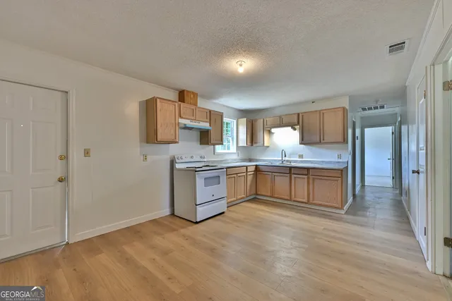 a large kitchen with kitchen island granite countertop a sink and cabinets
