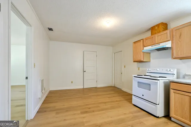 a view of a kitchen with stove and cabinets