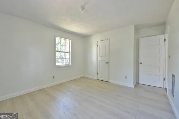 an empty room with wooden floor and window