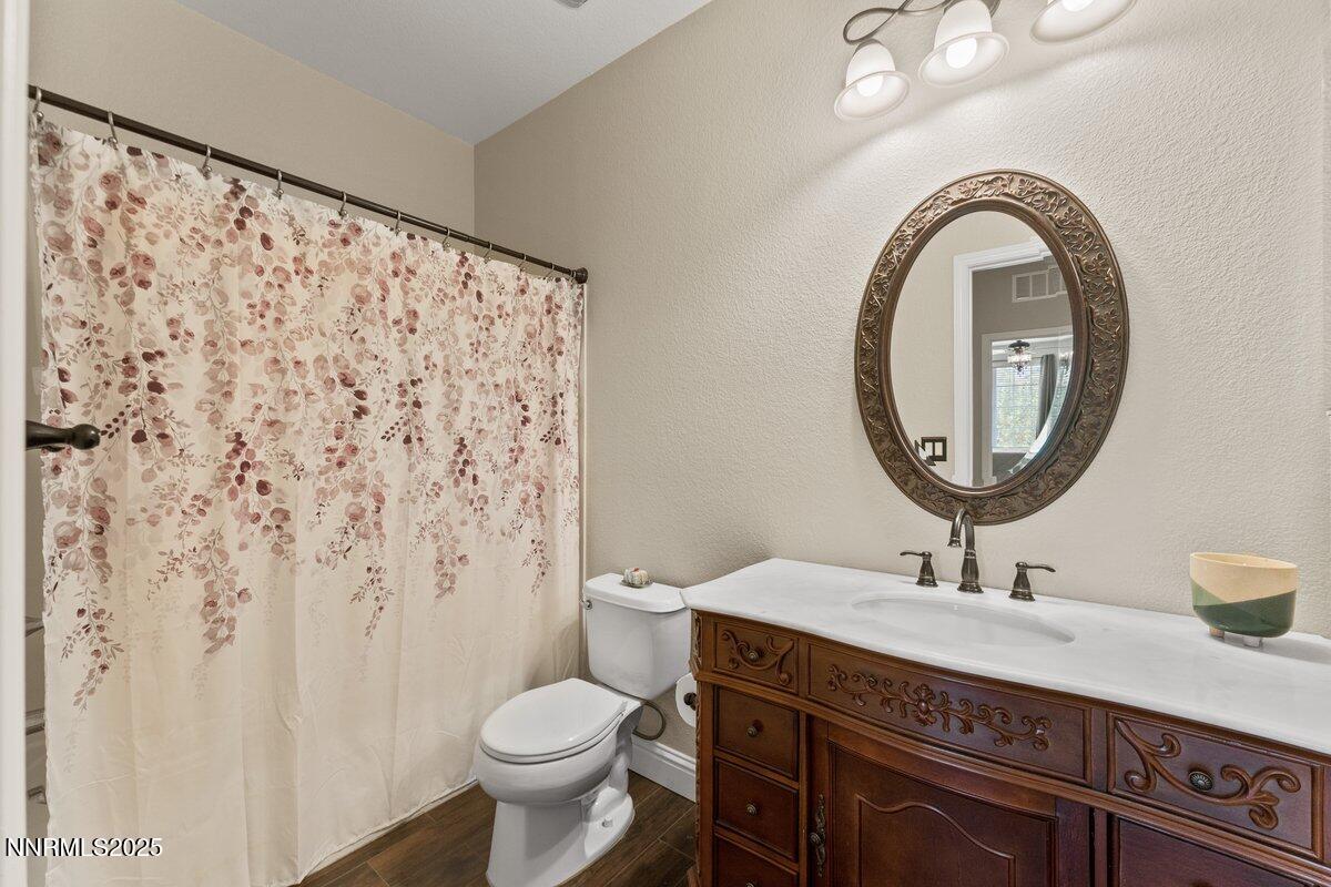 1955 Wind Ranch Road, Unit A Reno, NV 89521 - Photo 17 of 23 a bathroom with a granite countertop sink a toilet and a mirror