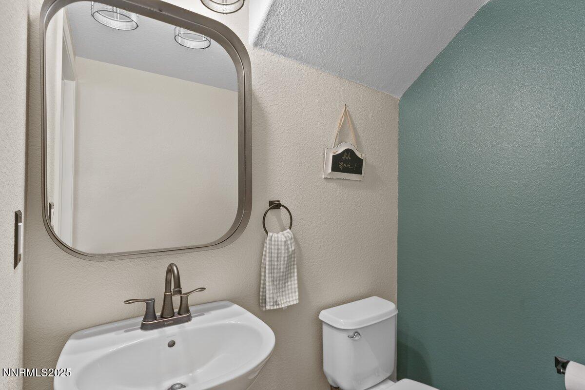 1955 Wind Ranch Road, Unit A Reno, NV 89521 - Photo 18 of 23 a bathroom with a toilet sink and mirror
