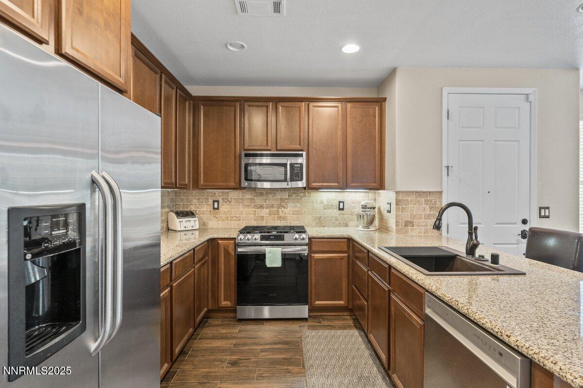 1955 Wind Ranch Road, Unit A Reno, NV 89521 - Photo 8 of 23 a kitchen with stainless steel appliances granite countertop a sink stove and refrigerator