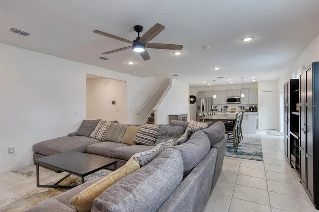 a kitchen with stainless steel appliances granite countertop a refrigerator a sink a stove and white cabinets with wooden floor