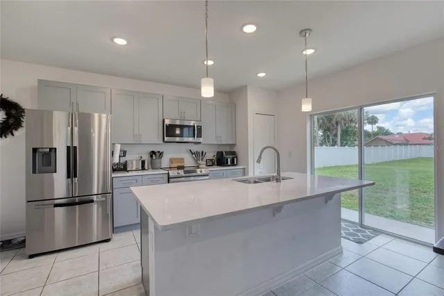 a kitchen with stainless steel appliances granite countertop a sink stove a refrigerator and cabinets