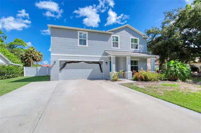 a front view of a house with a yard and a garage
