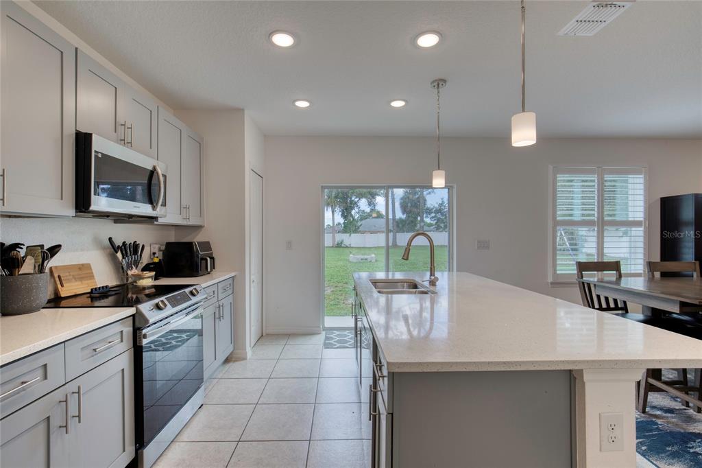 276 Farmbrook Road Port Orange, FL 32127 - Photo 21 of 62 a kitchen with a sink a microwave a stove and cabinets