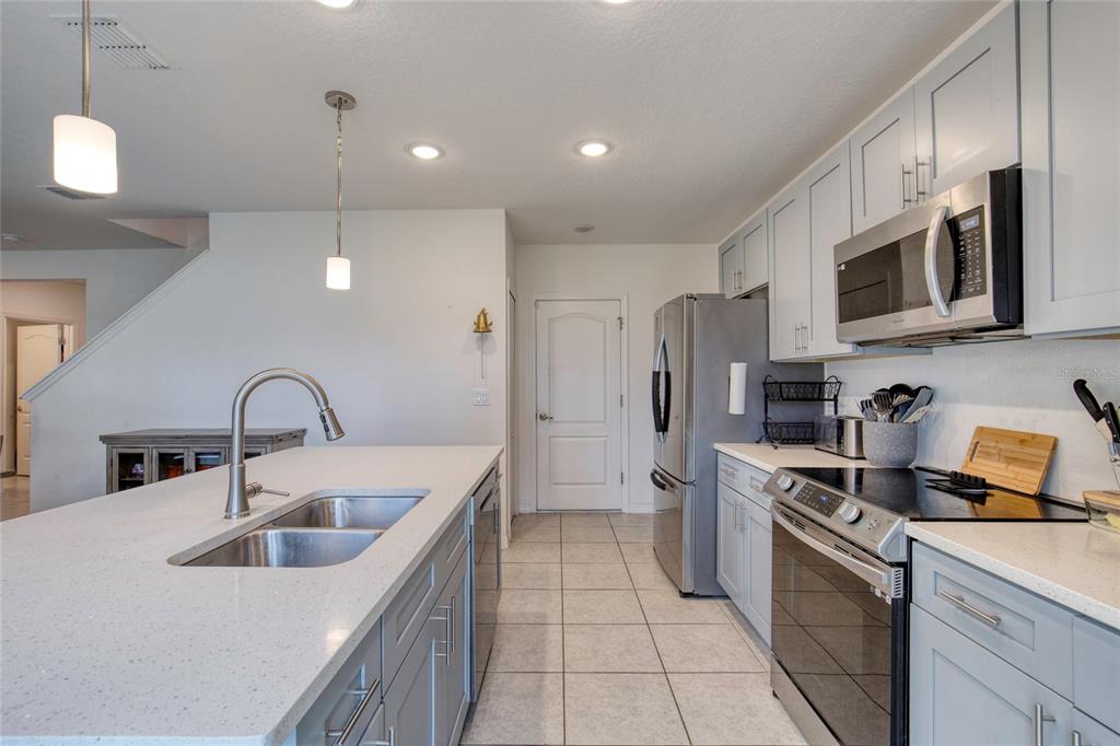 276 Farmbrook Road Port Orange, FL 32127 - Photo 23 of 62 a kitchen with stainless steel appliances granite countertop a sink stove a refrigerator and cabinets