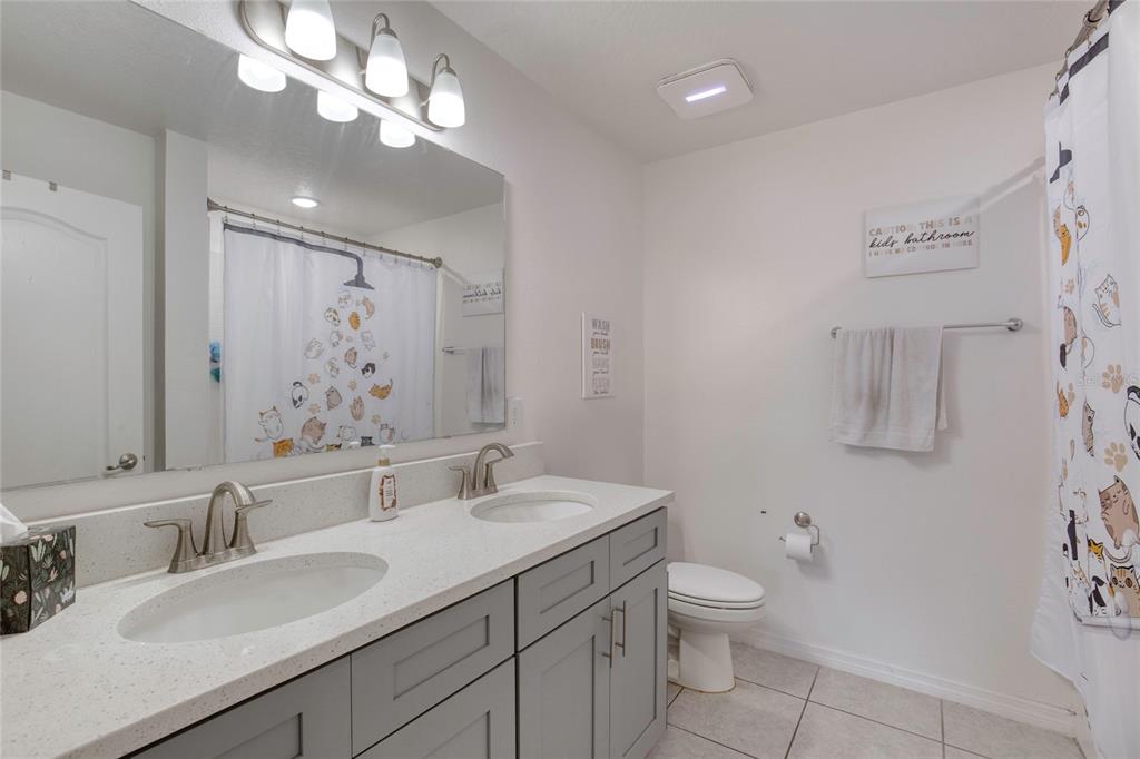 276 Farmbrook Road Port Orange, FL 32127 - Photo 30 of 62 a bathroom with a granite countertop sink a toilet and a mirror