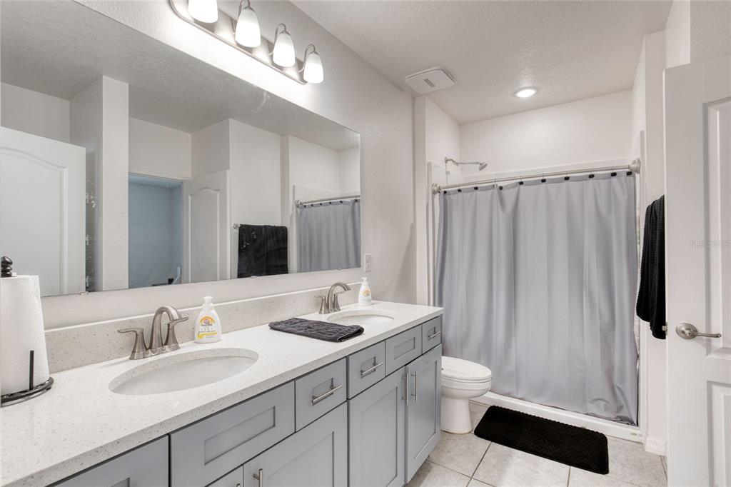 276 Farmbrook Road Port Orange, FL 32127 - Photo 9 of 62 a bathroom with a double vanity sink and a mirror