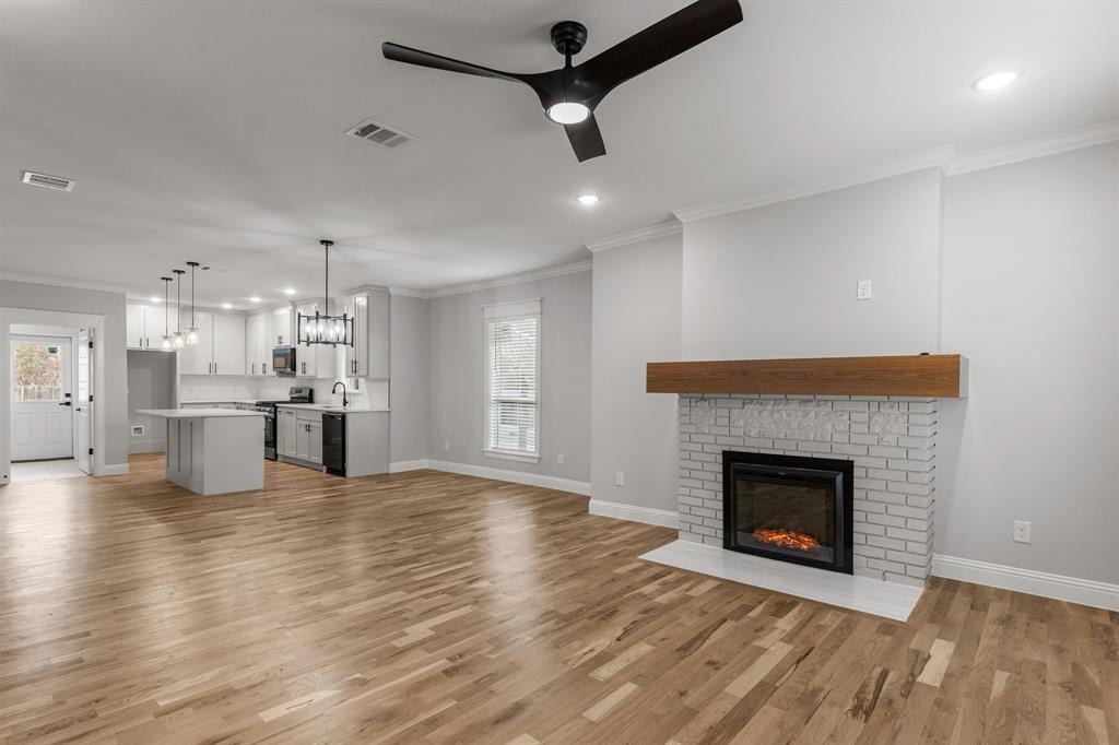 1616 Monroe Street Wichita Falls, TX 76309 - Photo 3 of 21 a view of a kitchen with a fireplace and wooden floor