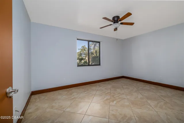 an empty room with window and ceiling fan