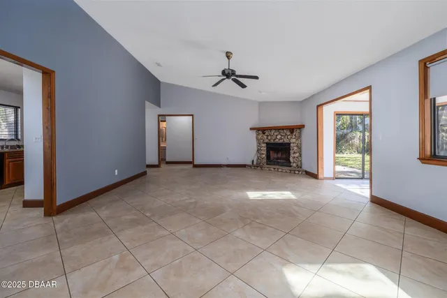 an empty room with windows and fireplace