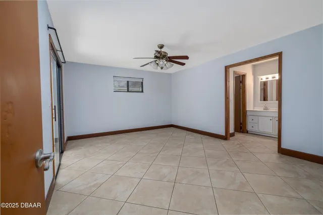an empty room with fan and windows
