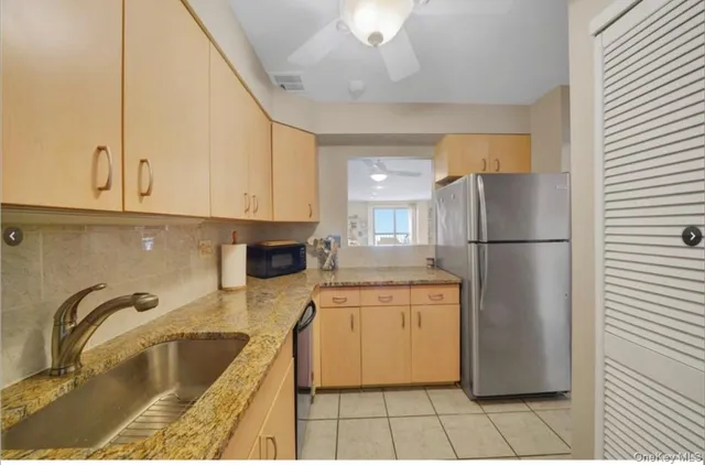 a kitchen with a refrigerator sink and cabinets