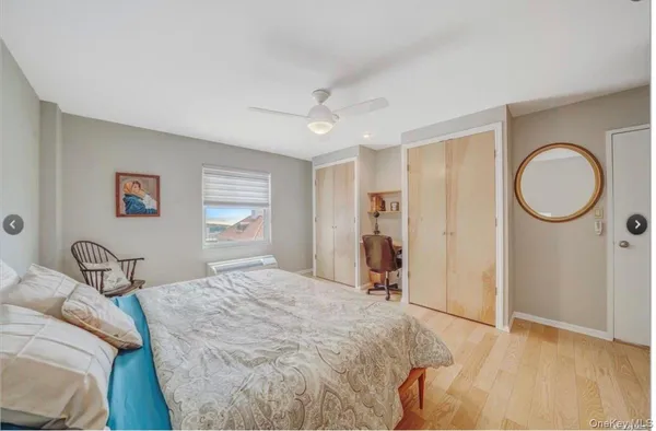 a bedroom with a bed a mirror and a window