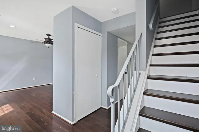 a view of a hallway with wooden floor and staircase