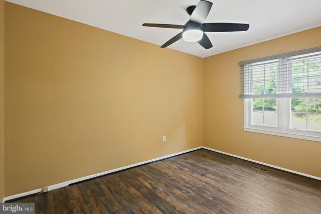 an empty room with a window and a ceiling fan