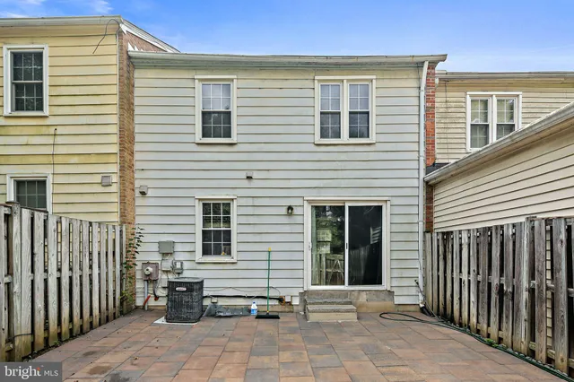 a view of a house with a small yard and wooden fence