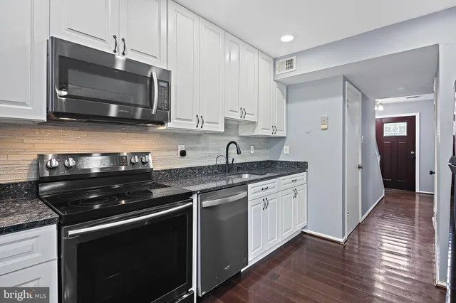 a kitchen with stainless steel appliances a sink dishwasher stove microwave and cabinets