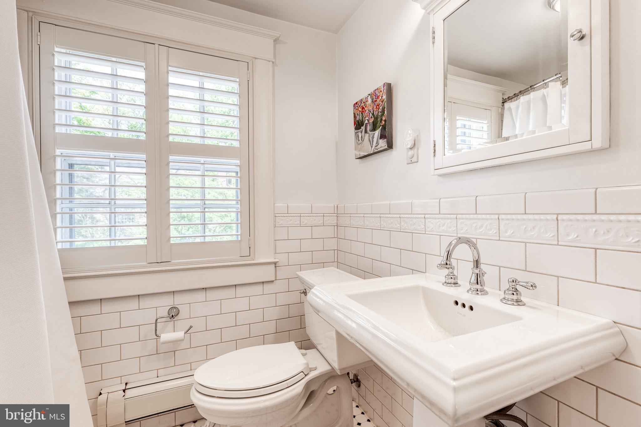 225 Tunbridge Road Baltimore, MD 21212 - Photo 44 of 65 a bathroom with a sink a toilet and a mirror
