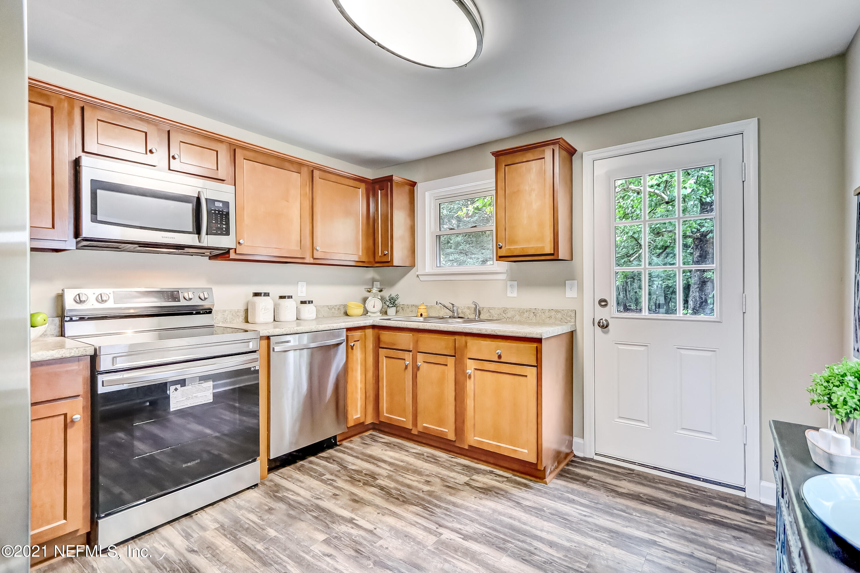 1416 Fred Gray Road Jacksonville, FL 32218 - Photo 23 of 34 a kitchen with stainless steel appliances granite countertop a stove a sink and a microwave