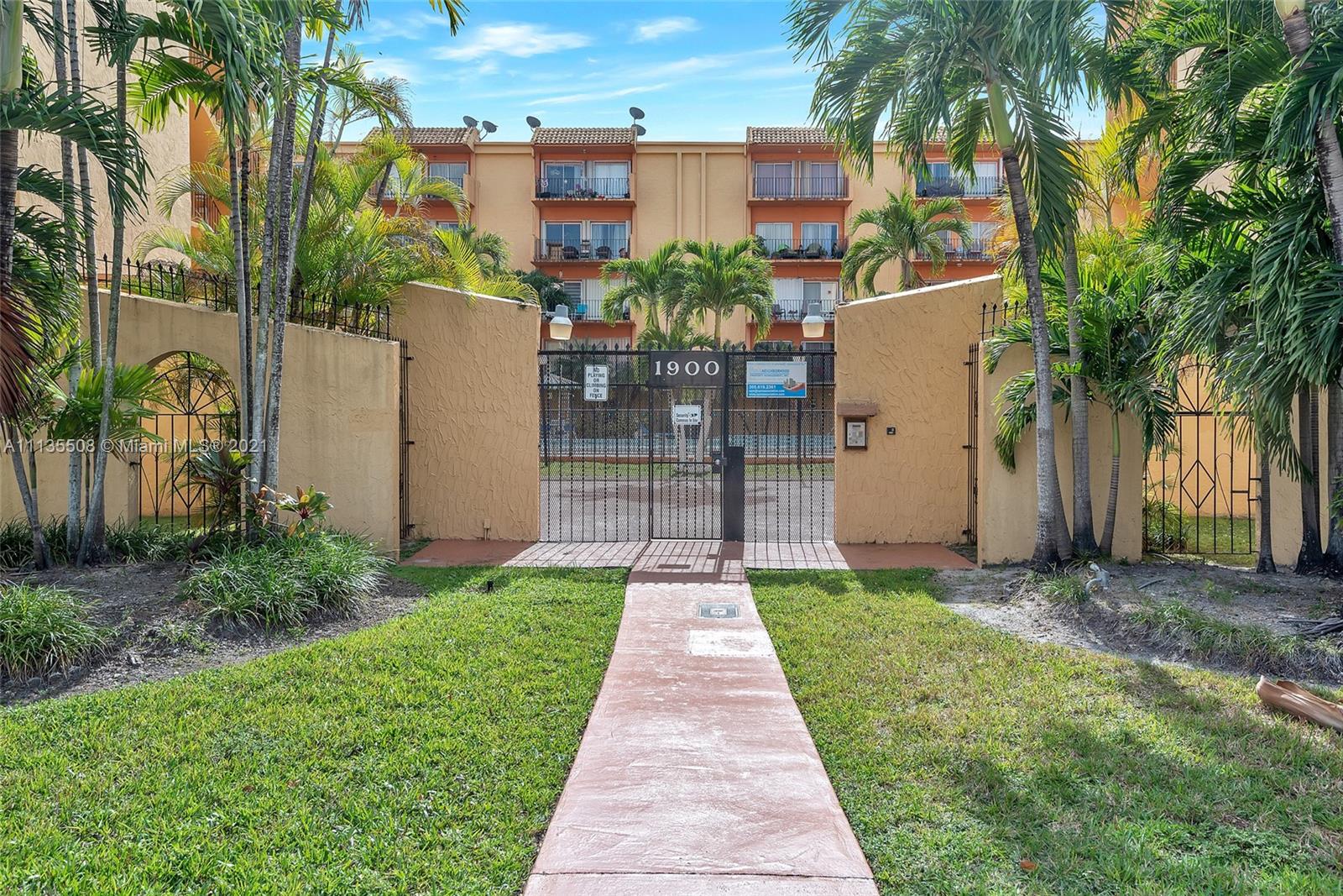 1900 West 54th Street, Unit 307 Hialeah, FL 33012 - Photo 1 of 49 a front view of a house with a yard and potted plants