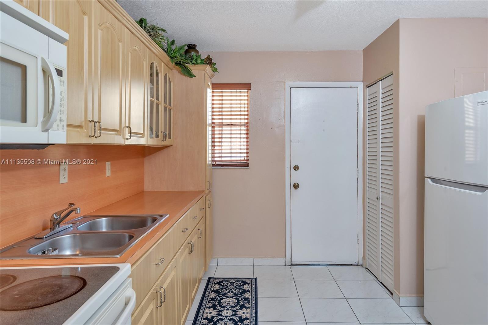 1900 West 54th Street, Unit 307 Hialeah, FL 33012 - Photo 24 of 49 a kitchen with a sink a refrigerator and cabinets
