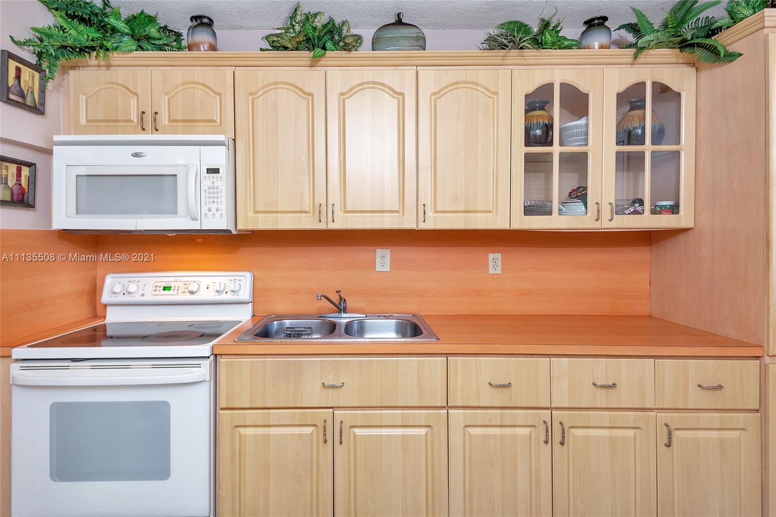 1900 West 54th Street, Unit 307 Hialeah, FL 33012 - Photo 26 of 49 a kitchen with cabinets and window