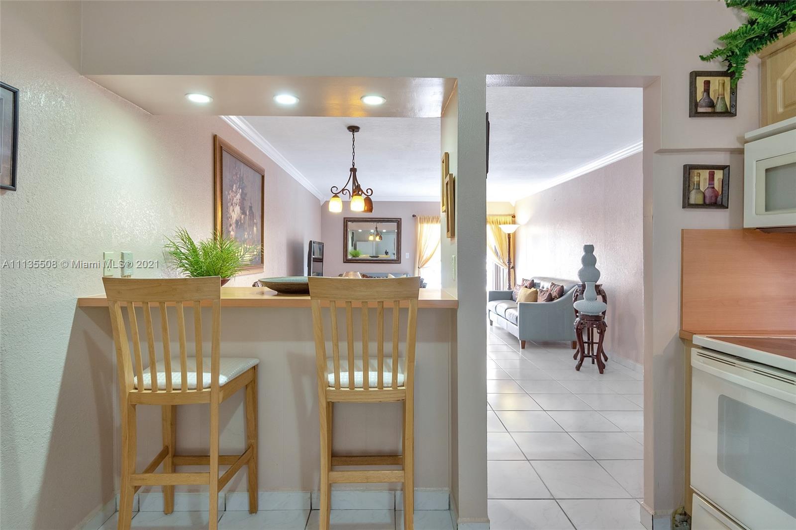 1900 West 54th Street, Unit 307 Hialeah, FL 33012 - Photo 30 of 49 a living room with furniture and a chandelier
