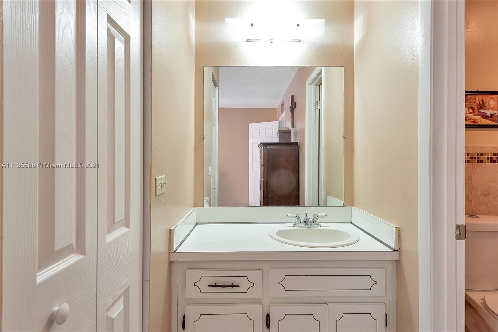 1900 West 54th Street, Unit 307 Hialeah, FL 33012 - Photo 37 of 49 a bathroom with a granite countertop sink and a mirror