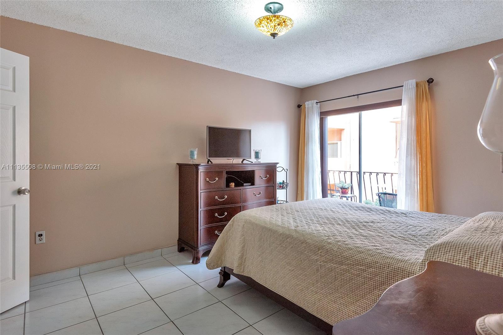 1900 West 54th Street, Unit 307 Hialeah, FL 33012 - Photo 39 of 49 a bedroom with a bed a dresser and a flat screen tv
