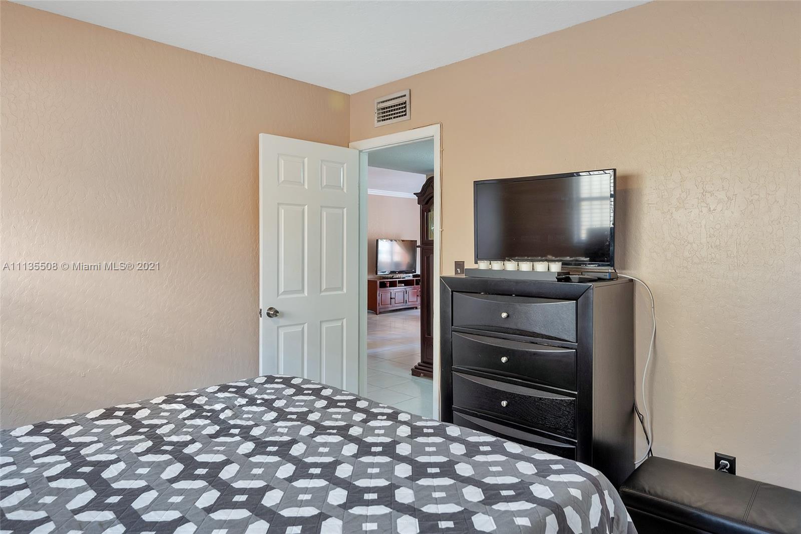 1900 West 54th Street, Unit 307 Hialeah, FL 33012 - Photo 47 of 49 a bedroom with a bed and a flat screen tv