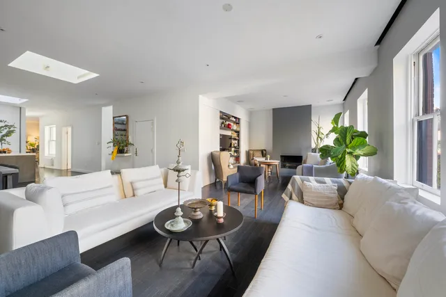 a living room with furniture wooden floor and a large window