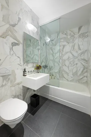 a kitchen with stainless steel appliances a stove refrigerator and a oven with wooden floor