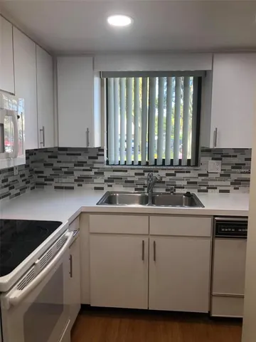 a kitchen with a sink stove and cabinets