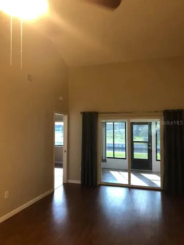 an empty room with large windows and a fireplace