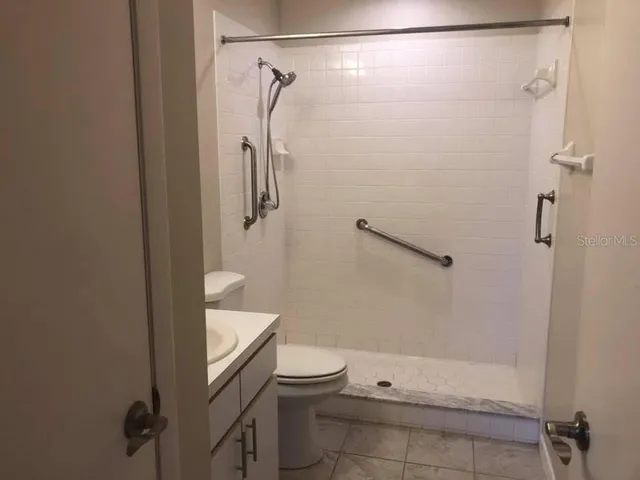 a bathroom with a granite countertop shower toilet and sink