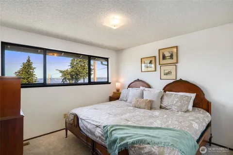 a bedroom with a bed and a painting on the wall