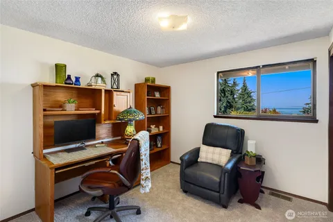 a view of a workspace with furniture and a window