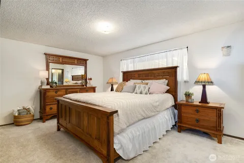 a bedroom with a bed and a dresser next to a window