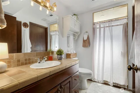 a bathroom with a granite countertop sink toilet and shower