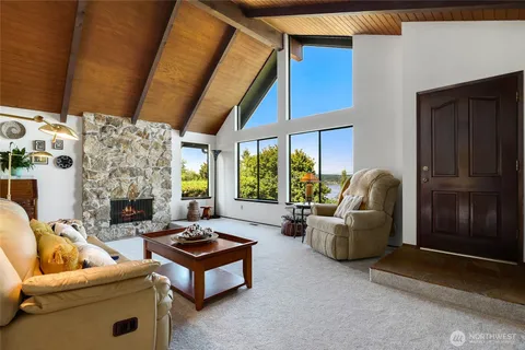 a living room with furniture a fireplace and a floor to ceiling window