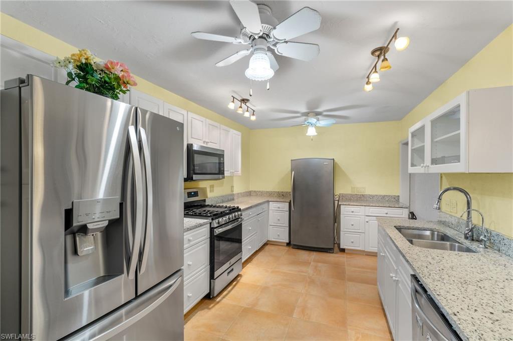 360 16th Avenue Northwest Naples, FL 34120 - Photo 8 of 25 a kitchen with granite countertop a refrigerator and a sink