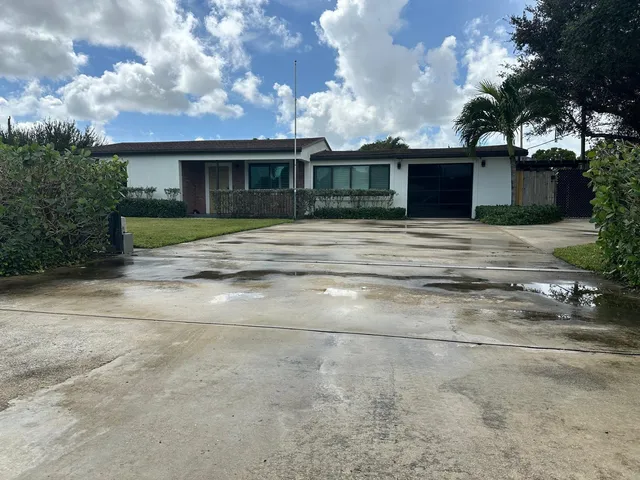 a front view of a house with a garden and trees