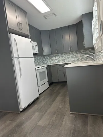 a view of a refrigerator and wooden floor