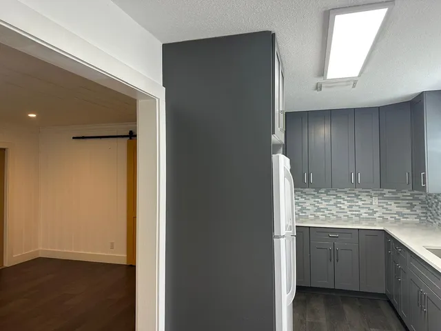 a view of cabinets a wooden floor and a window in a room