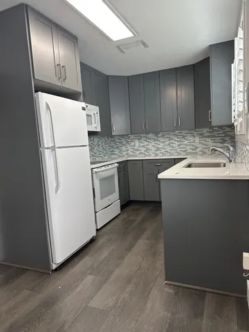 a kitchen with stainless steel appliances granite countertop a refrigerator a sink and a stove